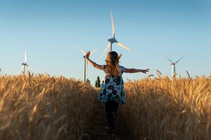 enfant dans des champs de blés avec éoliennes 